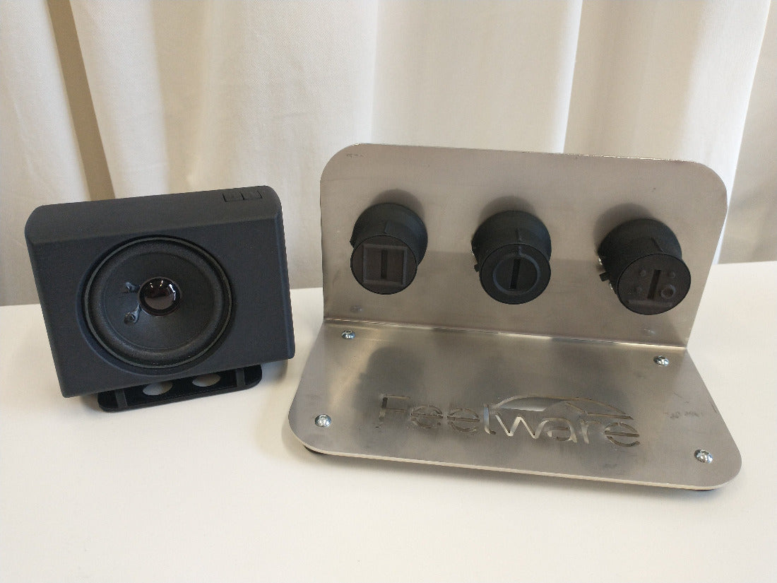 Demokit mit schwarzer AudioBox, einer Halterung mit drei Feelware Bedienknöpfen, zur Auswahl der Garfunktion, Temperaturwahl und Kochstelle. 
